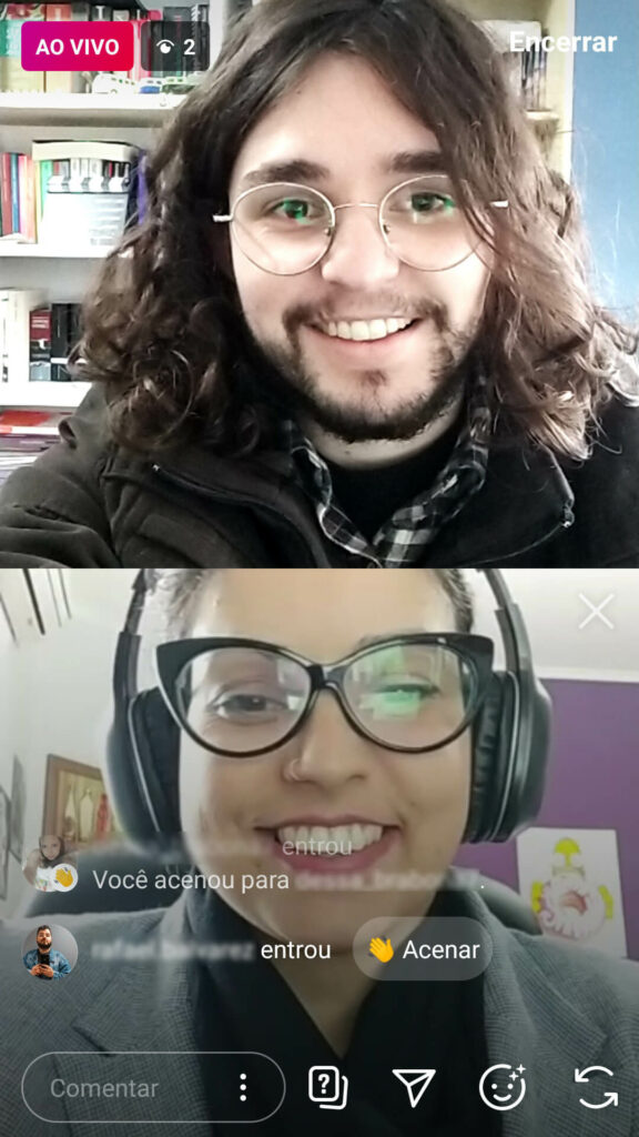 print mostra live com duas pessoas no Instagram. uma das pessoas é um homem branco de cabelos compridos e óculos, a outra é uma mulher branca usando óculos e fones de ouvido. Ambos sorriem.